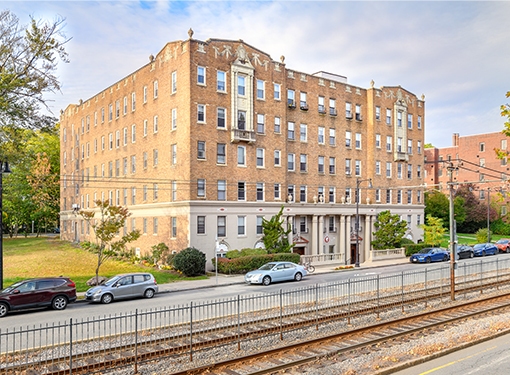 1940-50 Commonwealth building from train tracks with cars parked along street